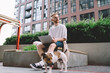 © BullRun - Positive young freelancer working on laptop in city street