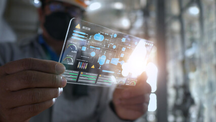 a factory maintenance worker looking at a production process model through a holographic screen.