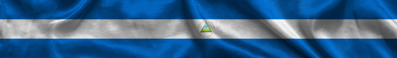 Elongated national flag of Nicaragua with a fabric texture fluttering in the wind. Nicaraguan flag for website design. 3d illustration