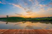 Wooden Table In The Water. Blurred Mountain Background And Sunset.