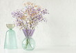 © irenastar - Flowers in a vase .Violet and beige gypsophila flowers  bouquet on glass vase selective focus on white table . Copy space. Modern interiour decor.