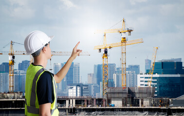 Wall Mural - Asian civil engineer or architecture,professional worker man wearing white hat,young adult man working at construction site ,Concept work in success.