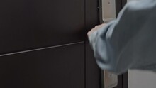 A Close-up Of A Woman's Hand Opens The Metal Black Door To The Apartment With A Key With The Key Fob Of The American Flag. Open The Lock In The Apartment.