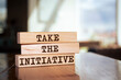 Wooden blocks with words 'Take the Initiative'.