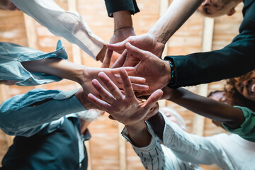 Group of businesspeople joining hands together standing in circle - Creative teamwork building concept