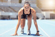 Woman runner start position on race track, competition or cardio for healthy exercise, workout and fitness in stadium. Focus young female sports athlete ready in running challenge, speed and marathon
