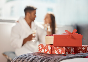 Poster - Christmas gift, present and happy couple celebrate the holiday at hotel with champagne. Love, happiness and vacation celebration of a girlfriend and boyfriend smile and drink in a bedroom together