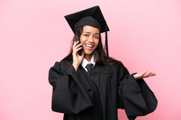 Wall Mural - Young university Colombian woman graduate isolated on pink background keeping a conversation with the mobile phone with someone