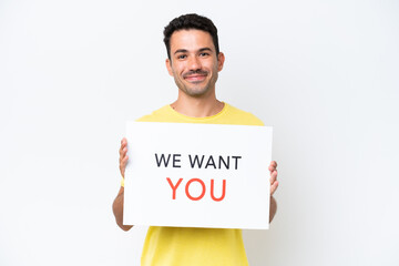 Young handsome man over isolated white background holding We Want You board with happy expression