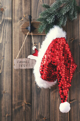 Wall Mural - Red santa hat hanging on wooden wall.