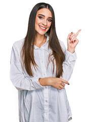Wall Mural - Young beautiful woman wearing casual white shirt smiling happy pointing with hand and finger to the side