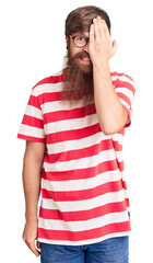 Wall Mural - Handsome young red head man with long beard wearing casual clothes covering one eye with hand, confident smile on face and surprise emotion.