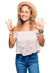 Wall Mural - Beautiful caucasian woman wearing summer hat showing and pointing up with fingers number nine while smiling confident and happy.