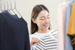 Choice of clothes,Nothing to wear. Attractive asian young woman, girl try on appare, happy choosing dress, outfit on hanger in wardrobe in room closet at home. Deciding blouse what to put on which one