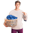 © Krakenimages.com - Young handsome man holding laundry basket pointing finger to one self smiling happy and proud
