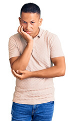 Wall Mural - Young handsome latin man wearing casual clothes thinking looking tired and bored with depression problems with crossed arms.