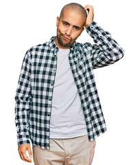 Canvas Print - Hispanic adult man wearing casual clothes confuse and wonder about question. uncertain with doubt, thinking with hand on head. pensive concept.