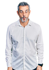 Canvas Print - Middle age hispanic with grey hair wearing casual white shirt making fish face with lips, crazy and comical gesture. funny expression.