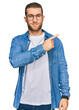 © Krakenimages.com - Young caucasian man wearing casual clothes pointing with hand finger to the side showing advertisement, serious and calm face