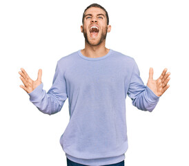 Canvas Print - Young caucasian man wearing casual clothes crazy and mad shouting and yelling with aggressive expression and arms raised. frustration concept.