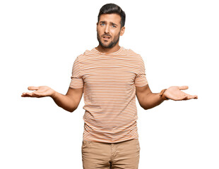 Wall Mural - Handsome hispanic man wearing casual clothes clueless and confused with open arms, no idea concept.
