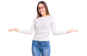 beautiful brunette young woman wearing casual white sweater and glasses smiling showing both hands o