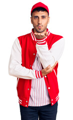 Canvas Print - Young hispanic man wearing baseball uniform looking at the camera blowing a kiss with hand on air being lovely and sexy. love expression.