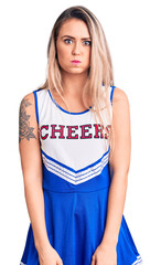 Poster - Young beautiful blonde woman wearing cheerleader uniform puffing cheeks with funny face. mouth inflated with air, crazy expression.