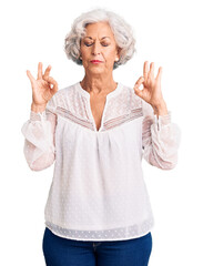 Wall Mural - Senior grey-haired woman wearing casual clothes relax and smiling with eyes closed doing meditation gesture with fingers. yoga concept.