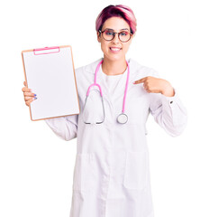 Sticker - Young beautiful woman with pink hair wearing doctor stethoscope holding clipboard with medical report pointing finger to one self smiling happy and proud