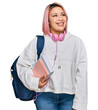 © Krakenimages.com - Hispanic woman with pink hair wearing student backpack and headphones looking away to side with smile on face, natural expression. laughing confident.