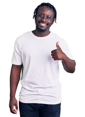 Sticker - Young african american man with braids wearing casual white tshirt doing happy thumbs up gesture with hand. approving expression looking at the camera showing success.