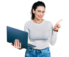 Young Hispanic Woman Working Using Computer Laptop Smiling Happy Pointing With Hand And Finger To The Side