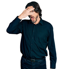 Canvas Print - Middle age caucasian man wearing casual clothes and glasses peeking in shock covering face and eyes with hand, looking through fingers with embarrassed expression.