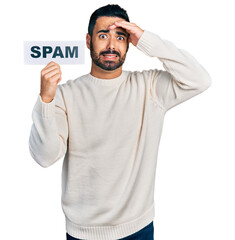 Sticker - Young hispanic man with beard holding spam banner stressed and frustrated with hand on head, surprised and angry face