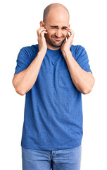 Canvas Print - Young handsome man wearing casual t shirt covering ears with fingers with annoyed expression for the noise of loud music. deaf concept.