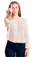 Poster - Young beautiful blonde woman wearing casual sweater pointing with finger up and angry expression, showing no gesture