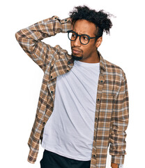 Wall Mural - Young african american man with beard wearing casual clothes and glasses confuse and wondering about question. uncertain with doubt, thinking with hand on head. pensive concept.