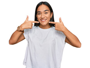 Canvas Print - Young asian woman wearing casual white t shirt smiling cheerful showing and pointing with fingers teeth and mouth. dental health concept.