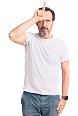 Poster - Middle age handsome man wearing casual t-shirt making fun of people with fingers on forehead doing loser gesture mocking and insulting.