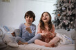 © alexkich - A family with children having fun on the bed under the covers during the Christmas holidays.