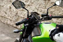 Green Motorcycle Is Near The Wall, In The City. Motorcycle Mobile Phone Mount, Holder.