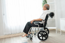 Portrait Of A Contented Elderly Man In Sitting On A Wheelchair At Home. Senior Person In Nursing House Service .
