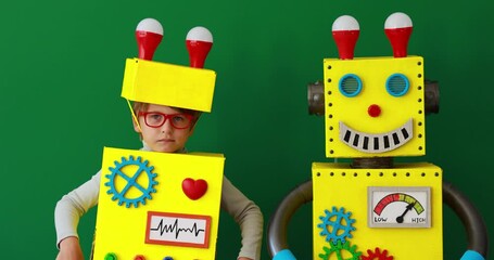 Canvas Print - Happy child wearing toy robot. Funny kid playing at home. Success, creative and innovation technology concept. Slow motion