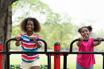 Wall Mural - Smiling two African American child girl playing together at the playground. Happy girls having fun at the playground outdoor