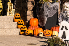 Halloween Outdoor Decorations Outside Haunted House With Pumpkins, Ghosts, Spider Webs, And Skeletons On Front Steps