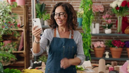 Sticker - Middle age woman florist smiling confident having video call at flower shop