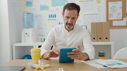 Wall Mural - Middle age man business worker using touchpad at office