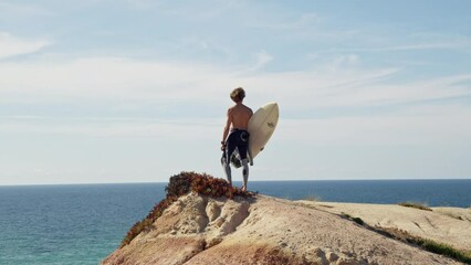 Wall Mural - Surfer holding surfboard at the hands and looking at the sea surface