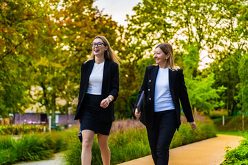 Two beautiful women walking in city park